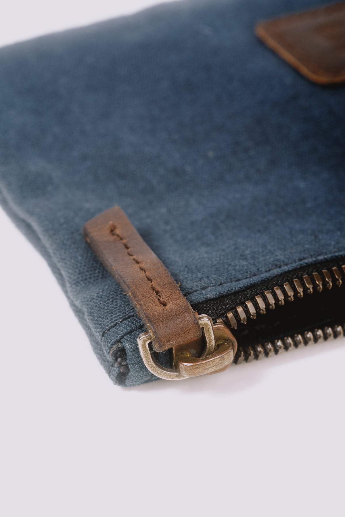 Close-up of a zipper of a navy blue pouch
