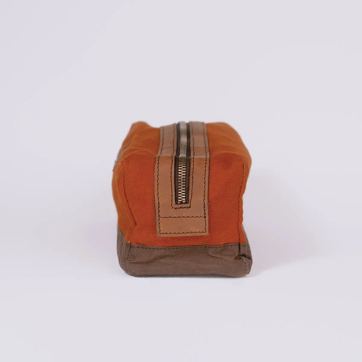 Side of a toiletry bag in rusty red