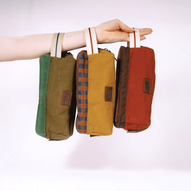Three cosmetic bags The Soil Travellers Kit hanging from hand