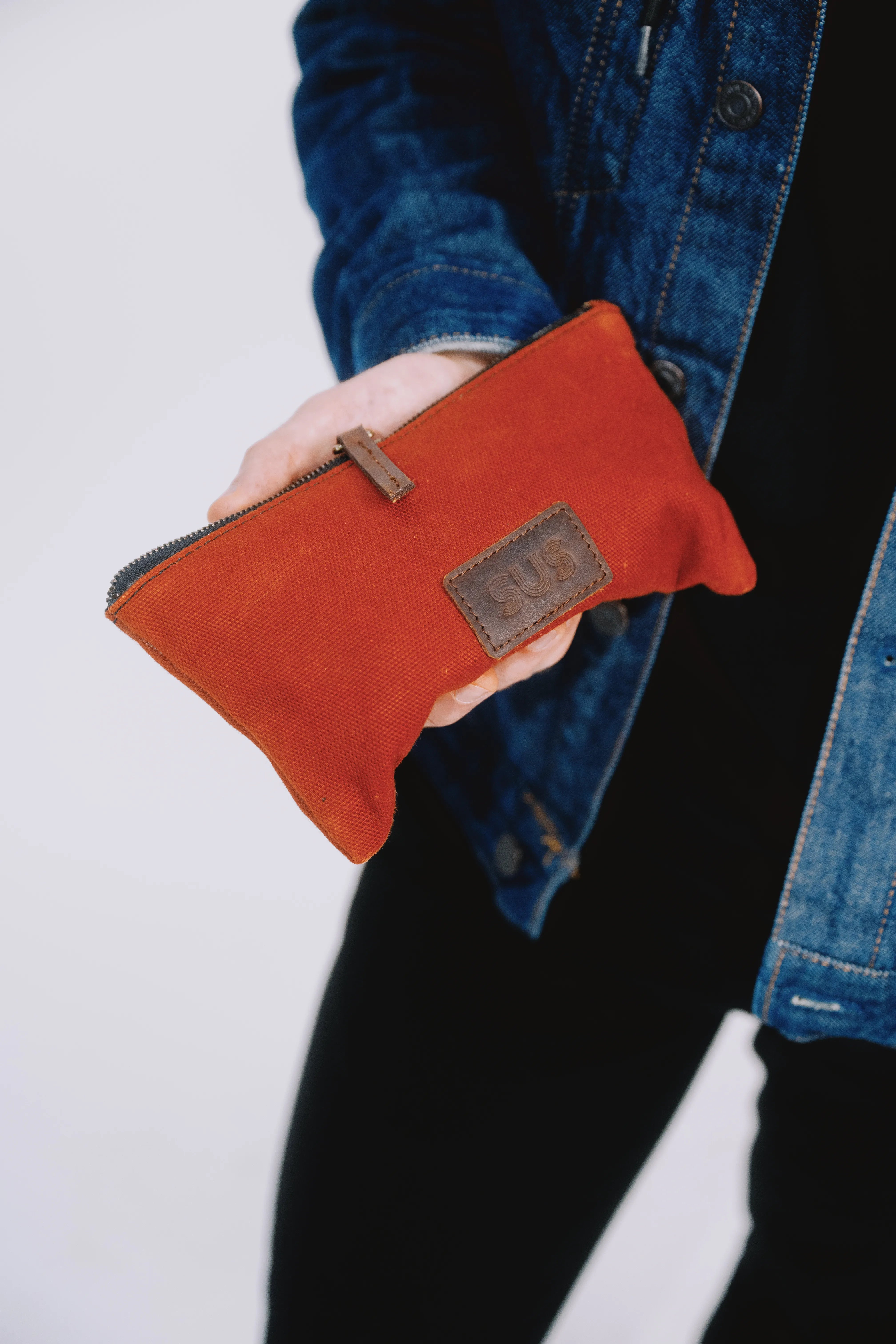 Burgundy red slim puch held in hand