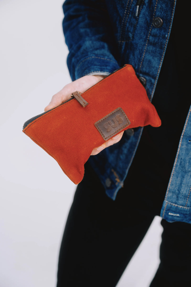 Burgundy red slim puch held in hand