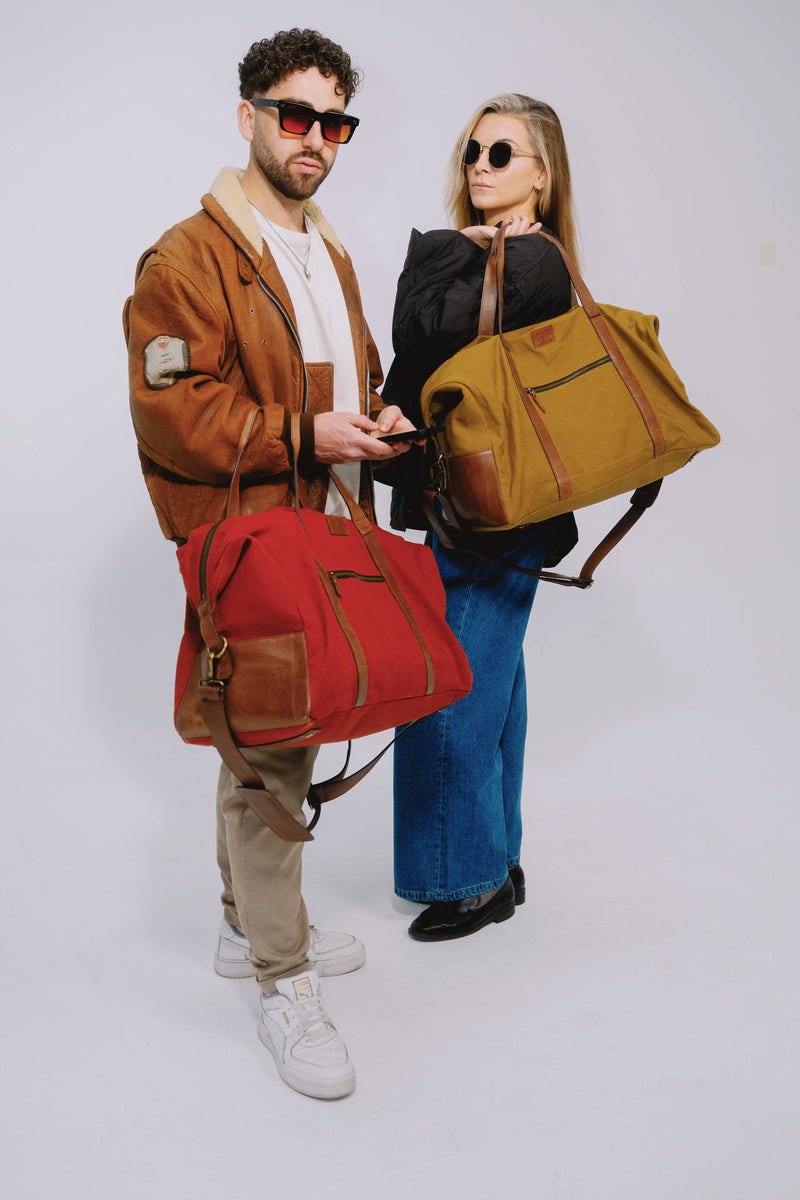 Two people holding stylish duffle bags